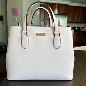 Light pink (shell) kate spade cow leather hand purse with shoulder strap.